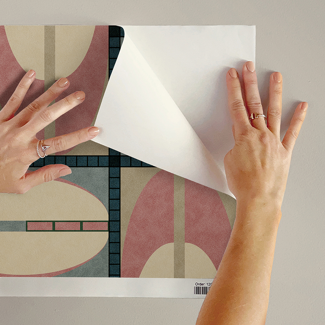 The artwork features a repeating geometric pattern of symmetrical shapes resembling elongated, curved diamonds or petals in various shades of blue and green. Each shape is split vertically with one half filled with a light blue and the other half filled with green or darker blue. The background is a light, almost pastel blue, which provides a soft yet vibrant backdrop. One of the blue shapes near the upper left contains a white starburst element, adding a focal point of brightness to the composition. The overall design conveys a modern, mid-century aesthetic with clean lines and harmonious color contrasts.